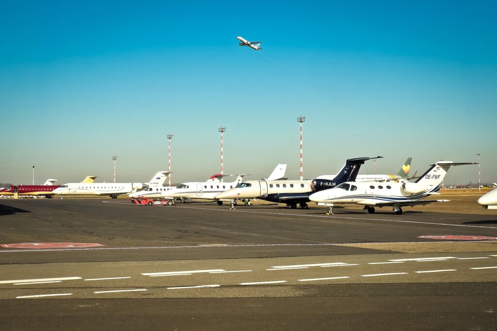 Several private jets positioned on a runway, preparing for takeoff.