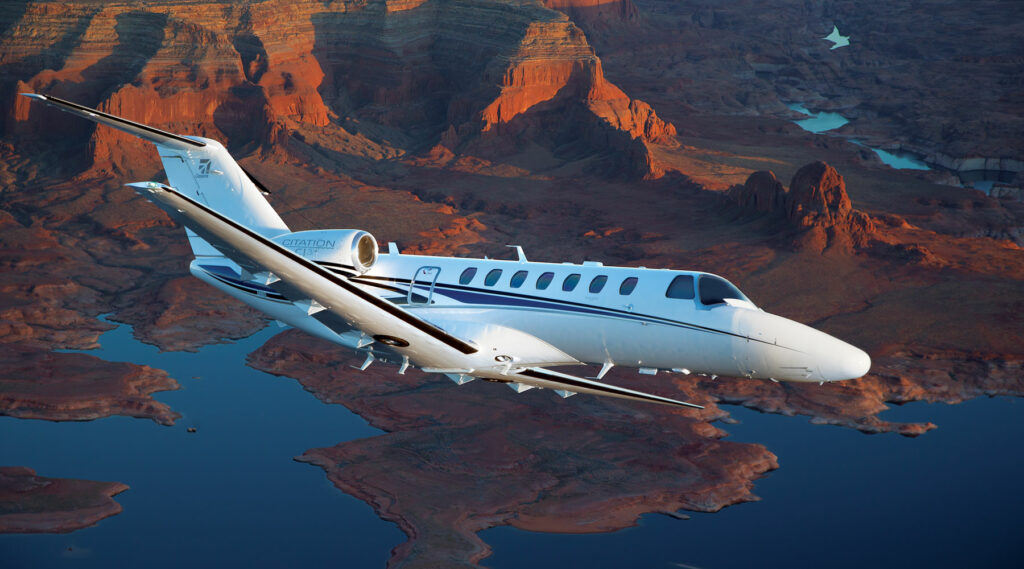 Private jet soaring gracefully through a clear blue sky, epitomizing luxury travel.