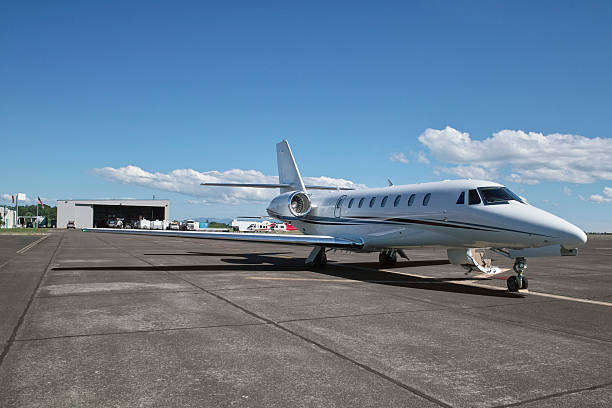 Luxury private jet positioned on the runway, preparing for takeoff under a clear sky.