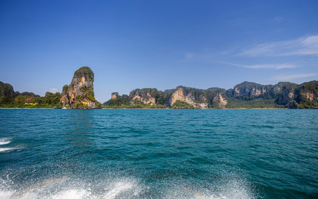 Scenic view of a sandy beach bordered by rugged cliffs.