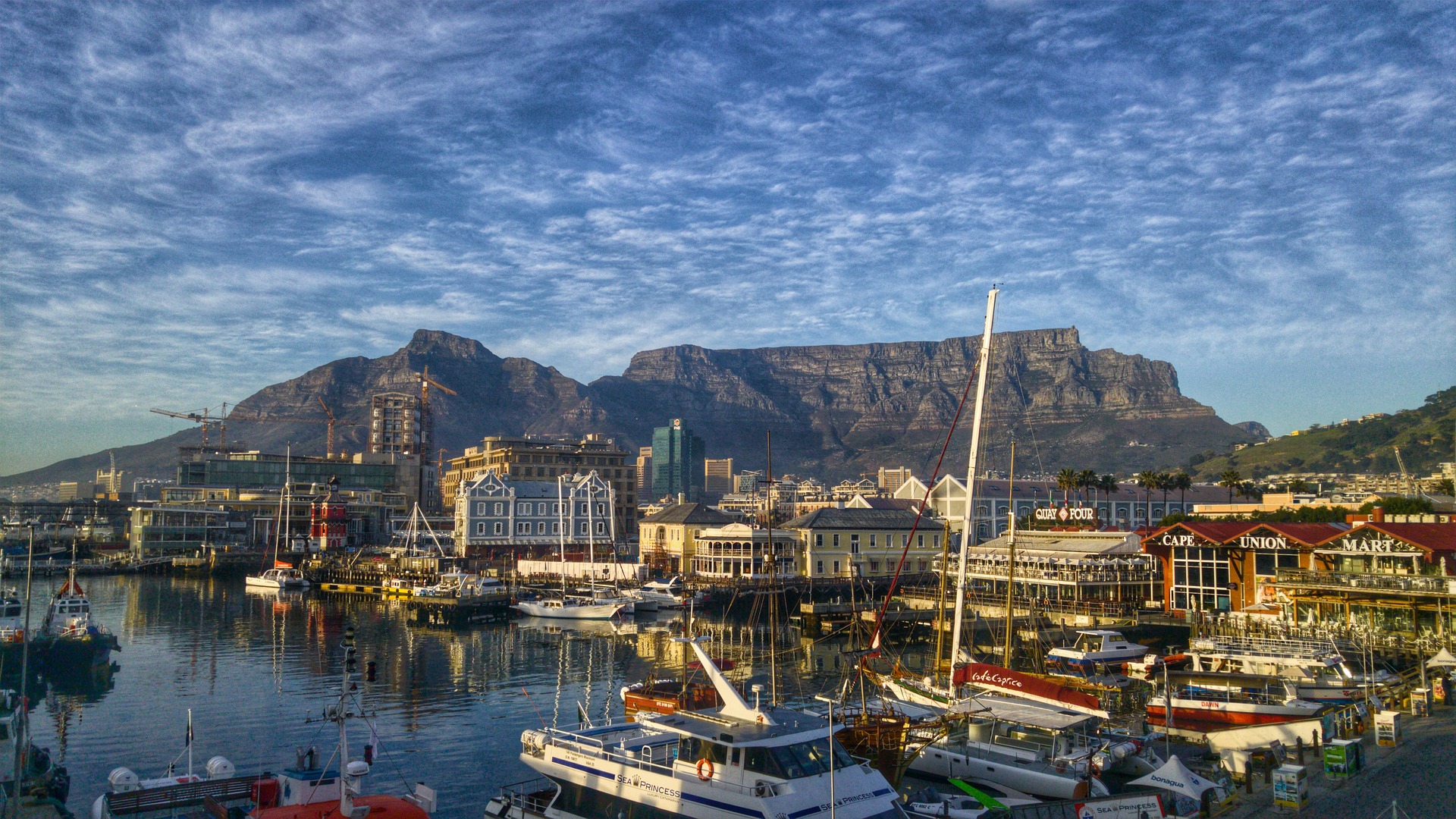 Yachts docked at a serene marina with calm waters.