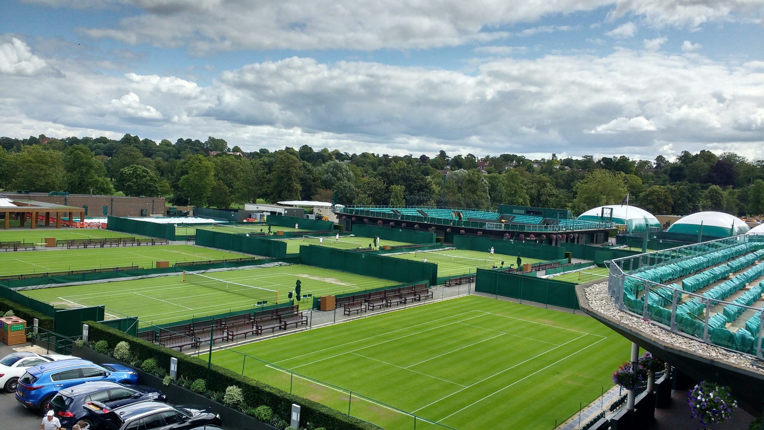 A lush green grass tennis court under a clear sky.