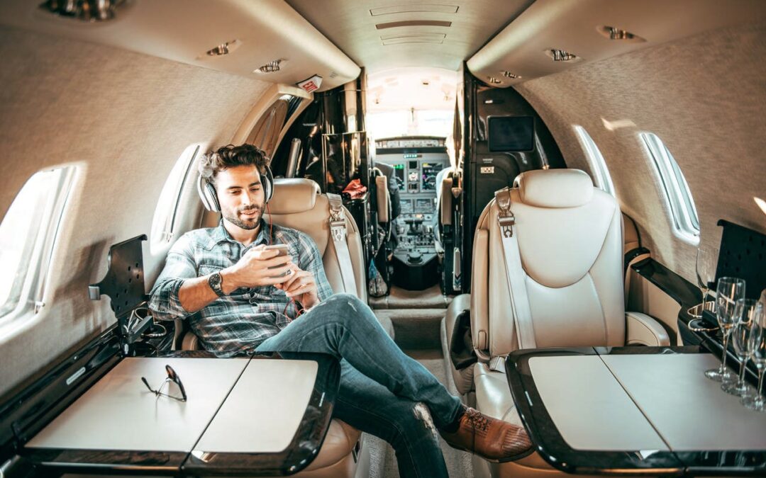 A man relaxing in a luxurious private jet, enjoying music with headphones.