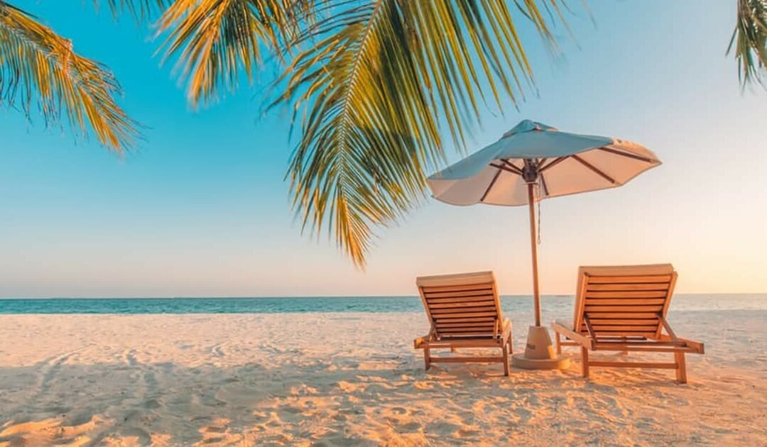 Two beach loungers with an umbrella, perfectly positioned on the sandy shore.