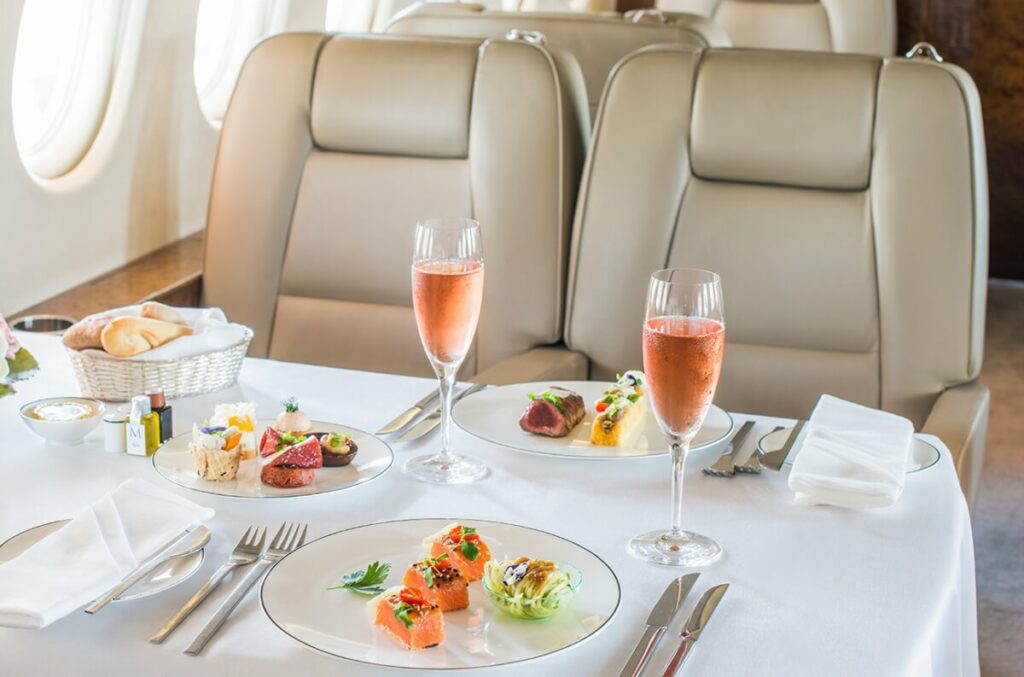 A luxurious dining table set with elegant wine glasses inside a private jet.