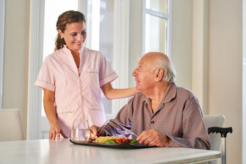 Compassionate woman assisting an elderly person with daily care activities.