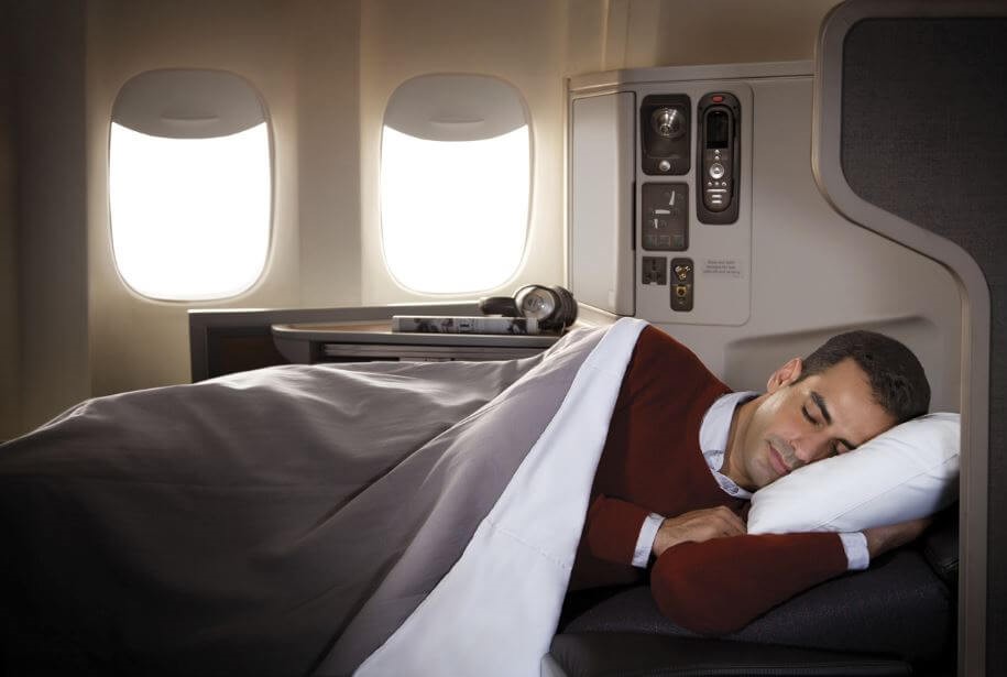 Man peacefully sleeping in the luxurious cabin of a private jet.